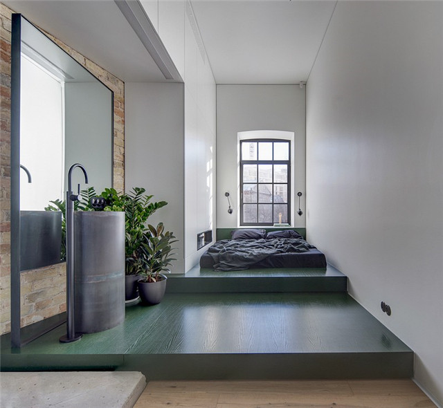 根据建筑的格局，将独立的空间规划为卧室区，通过架高的墨绿色地板，让这里变得悠闲自在。