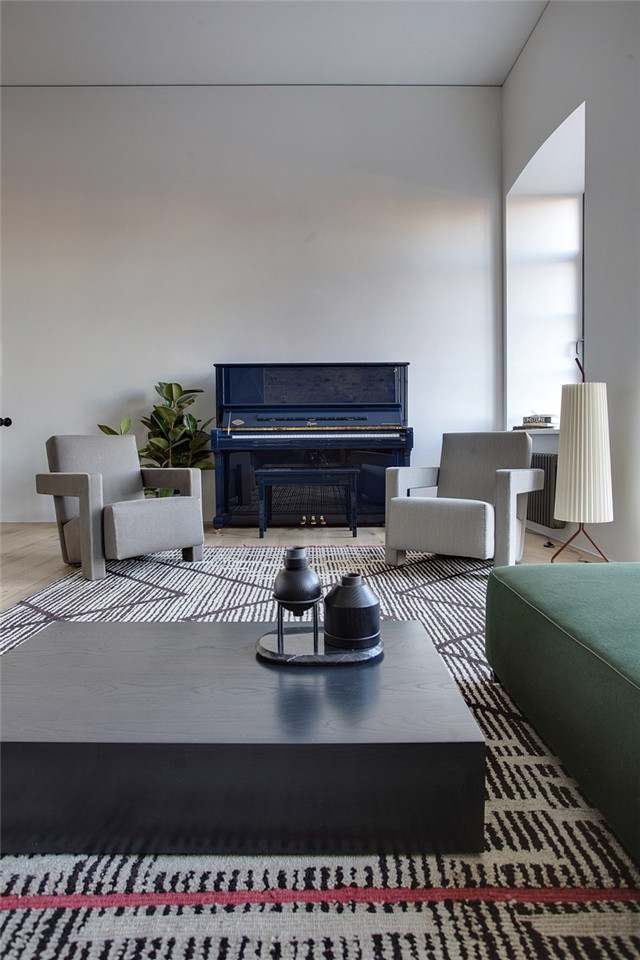 造型简洁的墨绿色沙发与灰色单人椅，带来现代与时尚，贴边摆放着宝蓝色的烤漆钢琴，让生活的气息蔓延整个空间。