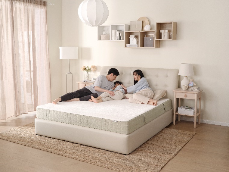 A group of people lying on a bed
Description automatically generated