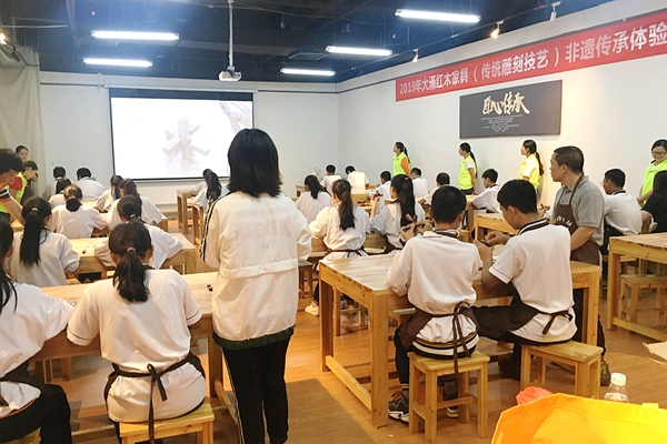 广大学子在学习红木雕刻技艺，体验纯粹的生活美学